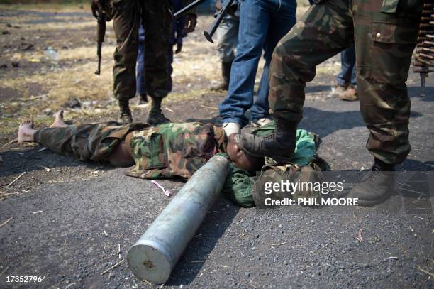 Congolese army soldiers desecrate the body of an alleged M23 fighter in Kanyarucinya, around 12kms from Goma in the east of the Democratic Republic...