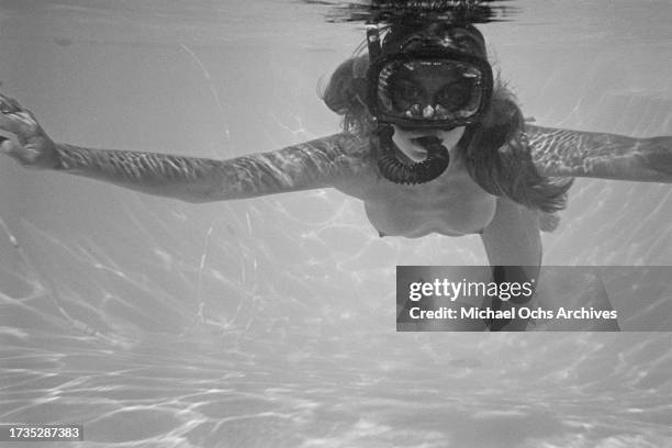 German actress and model Nastassja Kinski wearing a snorkel and mask as she swims in the swimming pool at her home in the Hollywood Hills, Los...