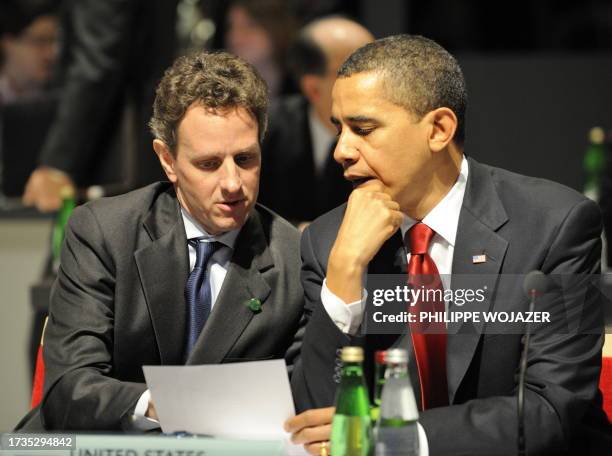 President Barack Obama speaks with US Treasury Secretary Timothy Geithner as they take part in a round table meeting in London on April 2, 2009...