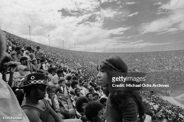 High-angle view of the crowds watching the Wattstax benefit concert, held during the 1972 Watts Summer Festival, at the Los Angeles Memorial Coliseum...
