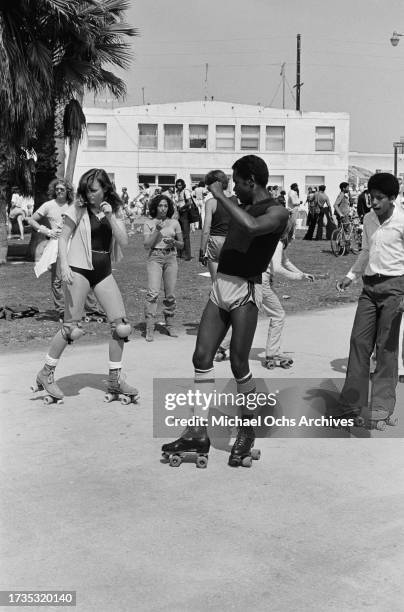 Roller skaters dancing on the beachfront of Venice Beach, in the Venice neighbourhood of Los Angeles, California, circa 1980.