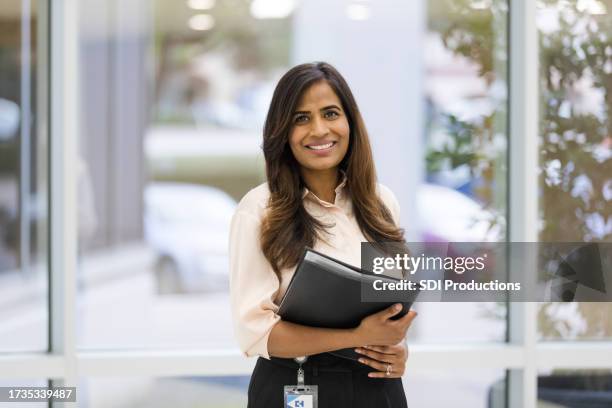 female administrator or social worker smiles for camera - maatschappelijk werker stockfoto's en -beelden