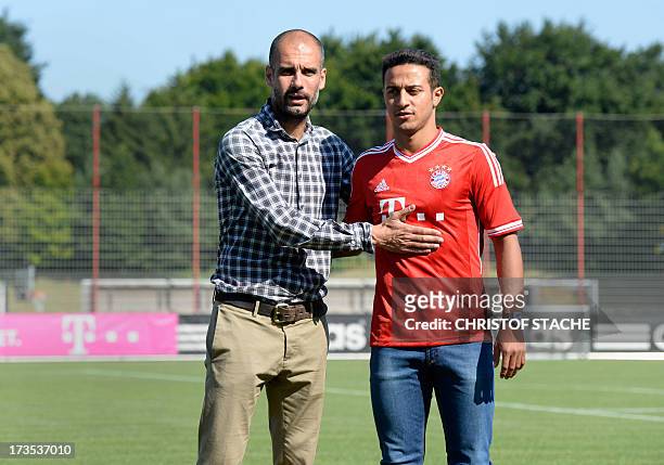 Bayern Munich's Spanish headcoach Pep Guardiola presents Bayern Munich's new Spanish midfielder Thiago Alcantara at their training grounds in Munich,...