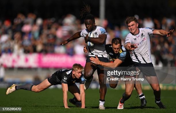 Rotimi Segun of Saracens is tackled by Josh Hodge and Tom Wyatt of Exeter Chiefs during the Gallagher Premiership Rugby match between Exeter Chiefs...