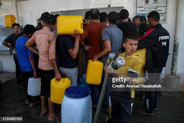 Palestinian citizens fill water from water stations in the street as residents of the Gaza Strip suffer from water and electricity outages due to...