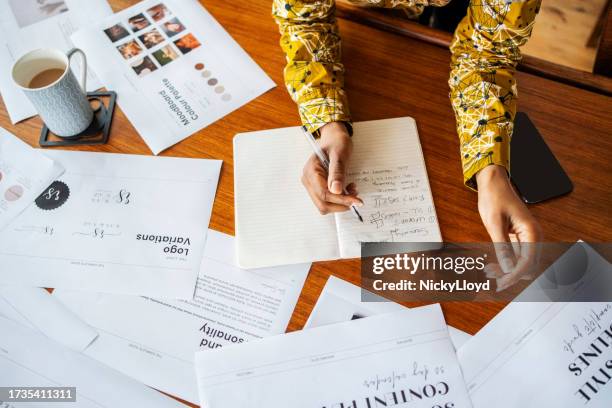 female designer working on new creative project making notes in a book on office desk - graphic designer sketching stock pictures, royalty-free photos & images