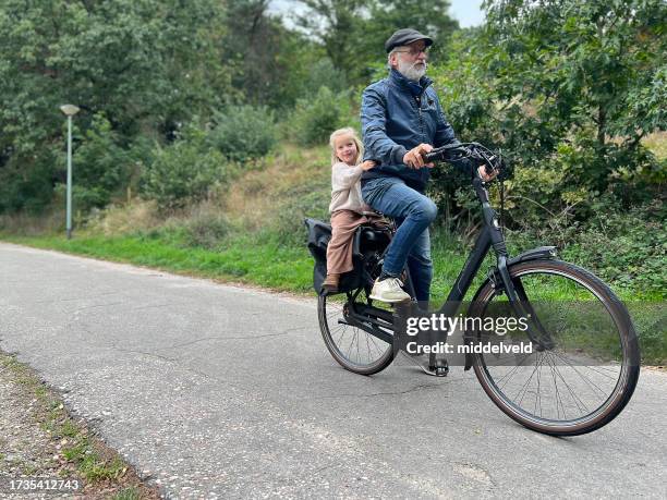 grandfather with granddaughter on e-bike - huis ter heide stockfoto's en -beelden