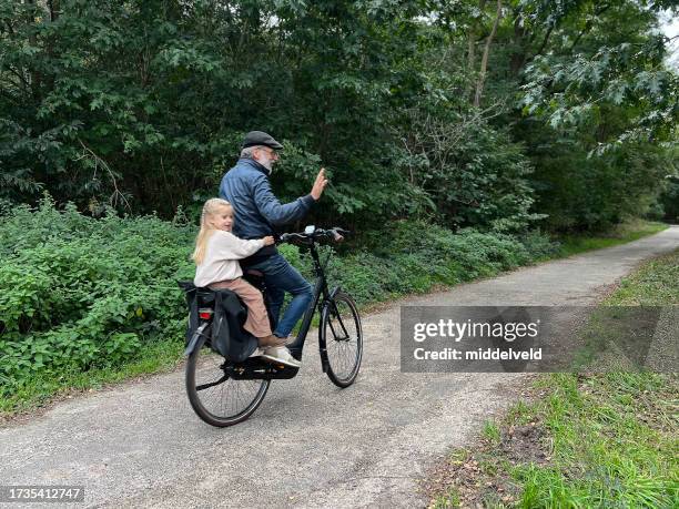 großvater mit enkelin auf e-bike - hollandrad stock-fotos und bilder