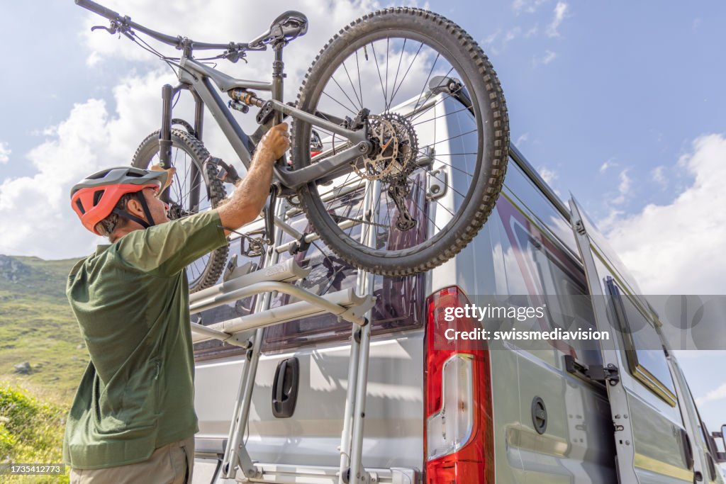 Mountain biker loads bike on camper van