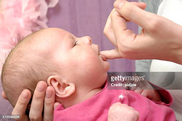 chupar la madre de bebé en la mano - sucking fotografías e imágenes de stock