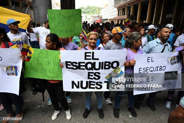 People gather in front of Venezuela's National Electoral Council headquarters in support of the referendum on a disputed zone with Guyana, in...