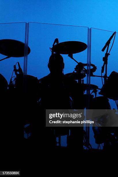 concert drummer and drum set with a bright blue background - drummer silhouette stock pictures, royalty-free photos & images