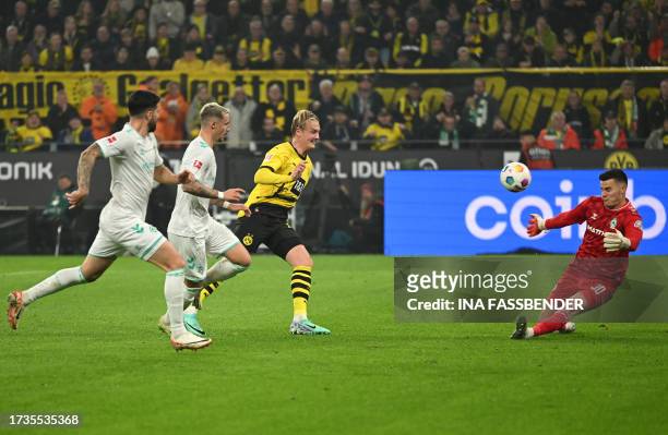 Dortmund's German midfielder Julian Brandt scores the opening goal past Bremen's German goalkeeper Michael Zetterer during the German first division...