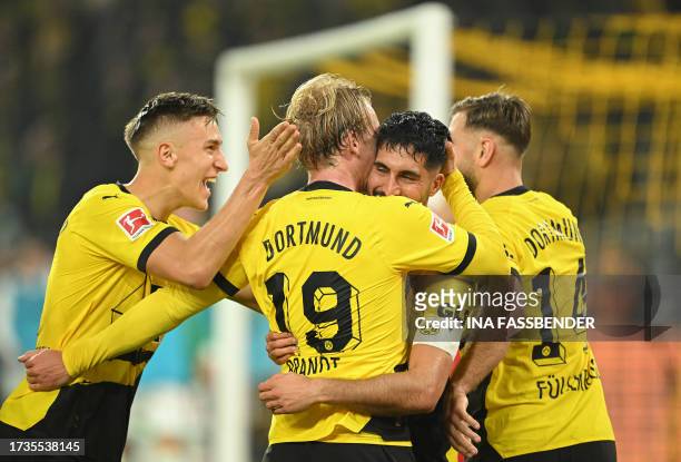 Dortmund's German midfielder Julian Brandt celebrates scoring the opening goal with his teammates during the German first division Bundesliga...