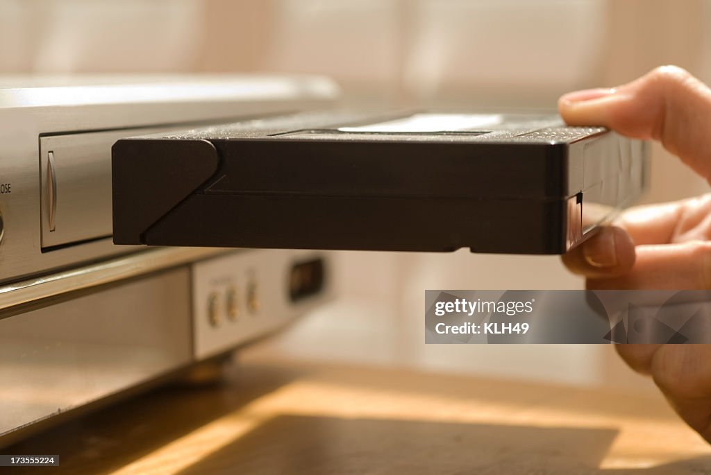 Hand putting VHS tape in a VCR