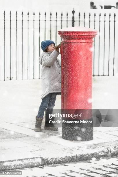 boy posting letter to santa claus in snow scene - message sent stock pictures, royalty-free photos & images