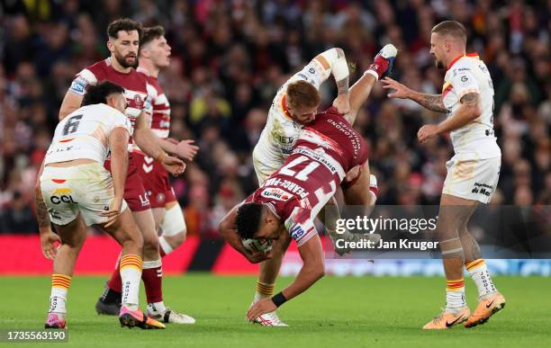 Kai Pearce-Paul of Wigan Warriors is tackled by Adam Keighran of Catalans Dragons during the Betfred Super League Final match between Wigan Warriors...