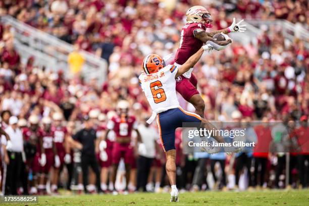 Keon Coleman of the Florida State Seminoles catches a pass against Jason Simmons jr. #6 of the Syracuse Orange during the first half of a game at...