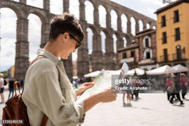 woman tourist looking at a map in a medieval town - segovia fotografías e imágenes de stock