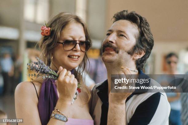 English rock musician Eric Clapton with girlfriend, model and photographer Pattie Boyd at a railway station in Germany, circa 1977. Boyd had recently...