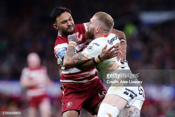 Sam Tomkins of Catalans Dragons is tackled by Bevan French of Wigan Warriors during the Betfred Super League Final match between Wigan Warriors v...