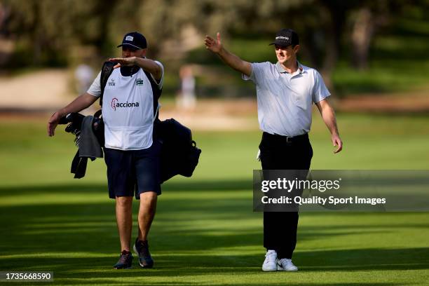 Justin Rose of England talks with his caddie on the 01st hole on Day Three of the acciona Open de Espana presented by Madrid at Club de Campo Villa...