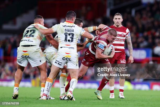 Morgan Smithies Wigan Warriors is tacked by Siosiua Taukeiaho Julian Bousquet and Benjamin Garcia of Catalans Dragons during the Betfred Super League...