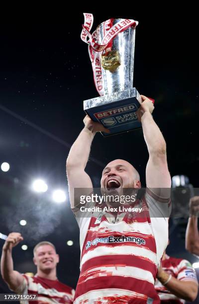 Liam Marshall of Wigan Warriors celebrates and lifts the Betfred Super League Grand Final trophy towards the fans during the Betfred Super League...