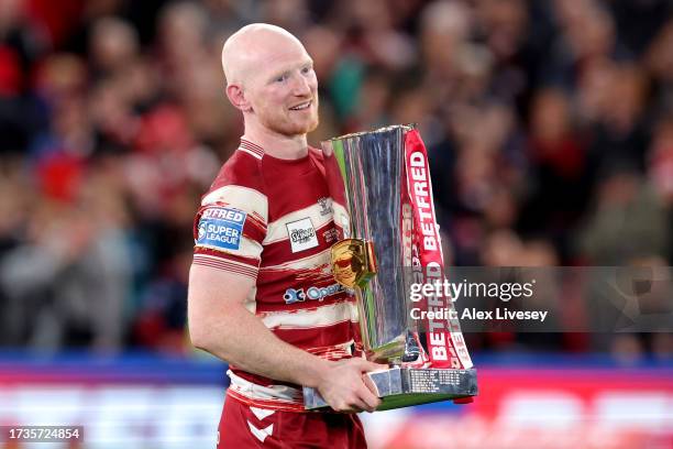 Liam Farrell of Wigan Warriors celebrates towards the crowd with the Betfred Super League Grand Final trophy during the Betfred Super League Final...