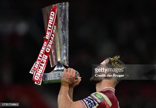 Jake Wardle of Wigan Warriors celebrates and lifts the Betfred Super League Grand Final trophy towards the fan during the Betfred Super League Final...
