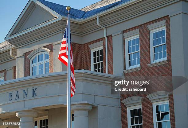 outside view of a bank with american flag - bank building stockfoto's en -beelden