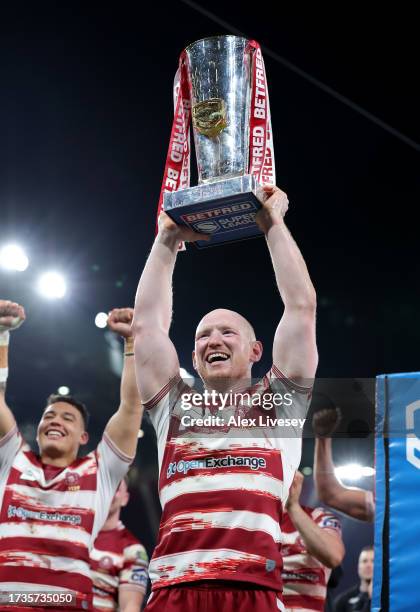 Liam Farrell of Wigan Warriors celebrates and lifts the Betfred Super League Grand Final trophy towards the fans during the Betfred Super League...