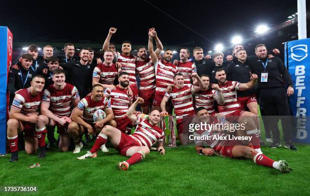 Players and staff of Wigan Warriors celebrate and pose for a photo with the Betfred Super League Grand Final trophy during the Betfred Super League...