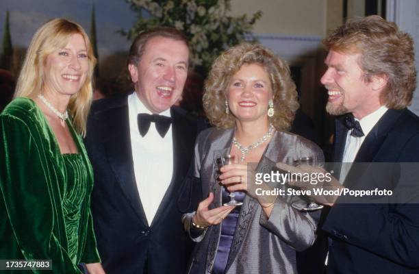 British journalist and satirical writer Sir David Frost with business tycoon Richard Branson and their wifes Lady Carina Fitzalan-Howard and Joan...