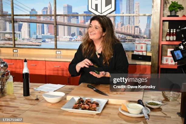 Alex Guarnaschelli prepares a dish during the Food Network New York City Wine & Food Festival presented by Capital One - Grand Tasting featuring...