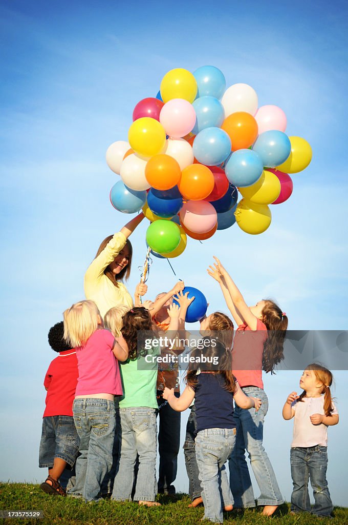 Group of Excited Children Reaching for Balloons