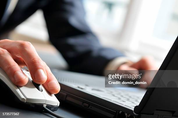 close-up of man's hand on computer mouse, working on laptop - mouse pad stock pictures, royalty-free photos & images