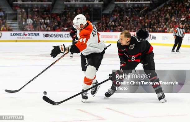 Nicolas Deslauriers of the Philadelphia Flyers battles for the puck with Jakob Chychrun of the Ottawa Senators as his helmet is knocked off in the...
