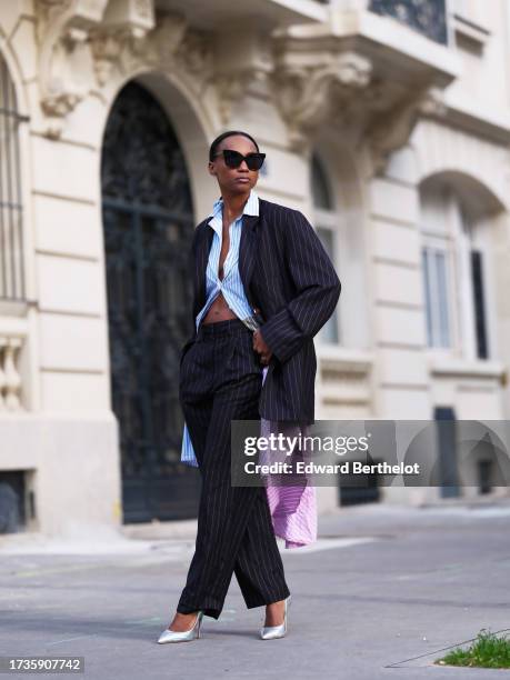 Emilie Joseph @in_fashionwetrust wears an office look, a colorful striped shirt dress by Jour/née, oversized pinstripe suit by Frankieshop,...