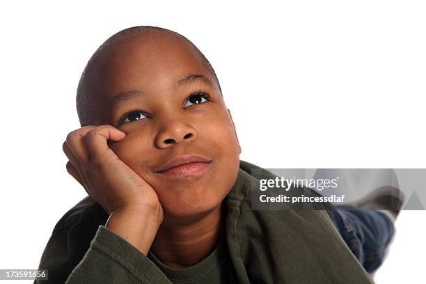 a young boy lying down daydreaming - boy lying down stock pictures, royalty-free photos & images