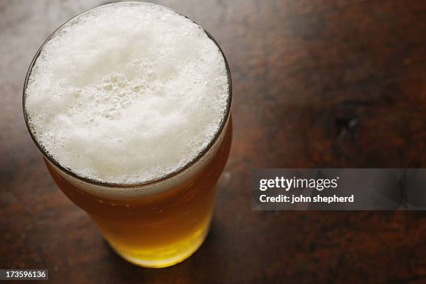 pint of lager from above - pint glass stock pictures, royalty-free photos & images