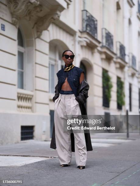 Emilie Joseph @in_fashionwetrust wears a sleeveless raw blue utility denim shirt by Massimo Dutti, double waisted wide leg dad pants by Frankieshop /...
