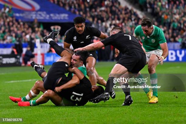 James Lowe of Ireland is tackled by Leicester Fainga'anuku and Rieko Ioane of New Zealand during the Rugby World Cup France 2023 Quarter Final match...