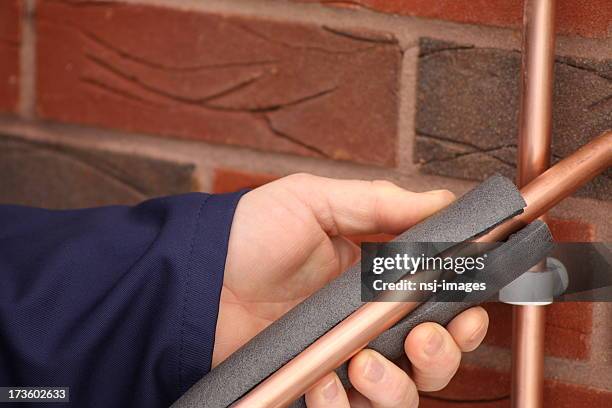 insulating a copper water pipe - isolatiemateriaal stockfoto's en -beelden