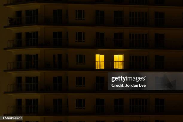 only window with light in a black out apartment - power cut stock pictures, royalty-free photos & images