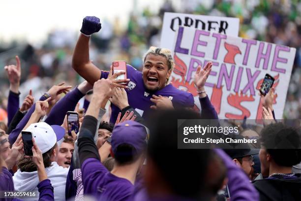 Rome Odunze of the Washington Huskies celebrates as fans storm the field after the Washington Huskies beat the Oregon Ducks 36-33 at Husky Stadium on...