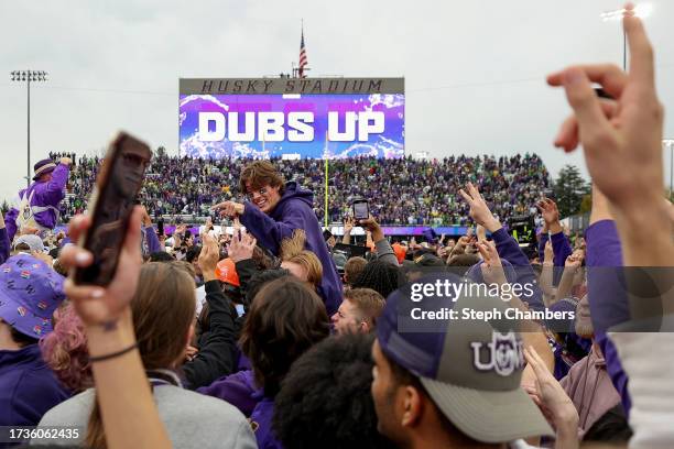 Fans storm the field after the Washington Huskies beat the Oregon Ducks 36-33 at Husky Stadium on October 14, 2023 in Seattle, Washington.