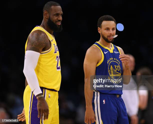 LeBron James of the Los Angeles Lakers and Stephen Curry of the Golden State Warriors smile at center court before the start of a preseason game at...