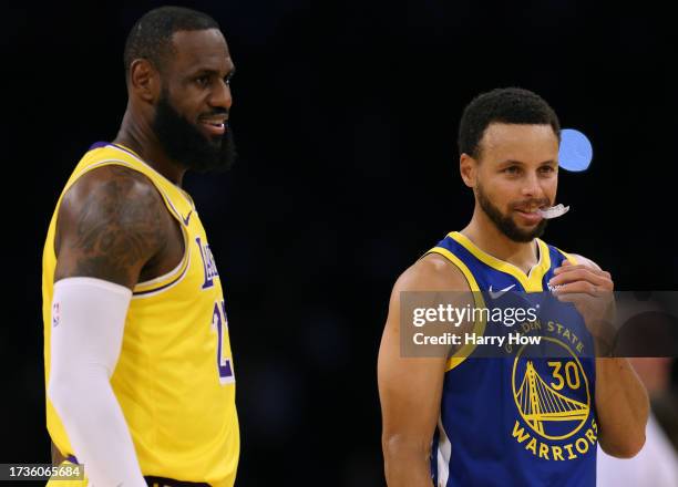 LeBron James of the Los Angeles Lakers and Stephen Curry of the Golden State Warriors smile at center court before the start of a preseason game at...