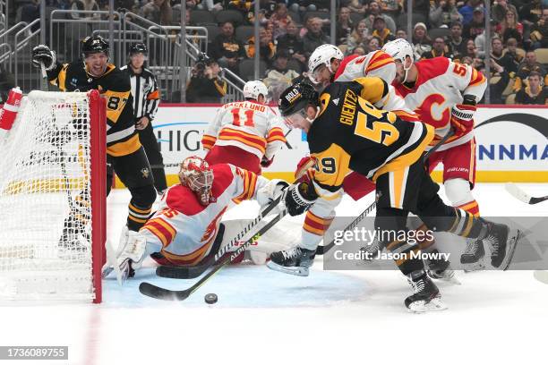 Jacob Markstrom of the Calgary Flames tends net as Jake Guentzel of the Pittsburgh Penguins shoots the puck during the first period at PPG PAINTS...